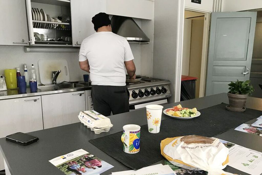 Paperiton mies laittaa ruokaa Helsingin Diakonissalaitoksen päiväkeskuksessa.