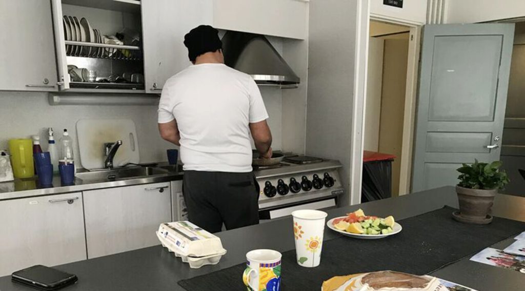 Paperiton mies laittaa ruokaa Helsingin Diakonissalaitoksen päiväkeskuksessa.