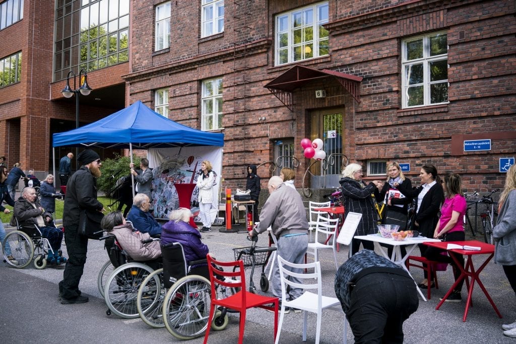 Asukkaita kokoontunut pihalle.