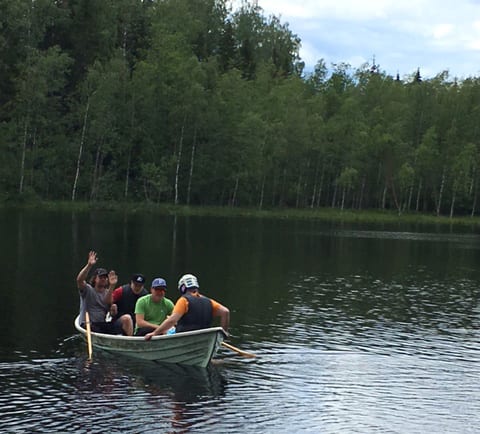 Neljä henkilöä soutaa soutuveneellä Majalammella