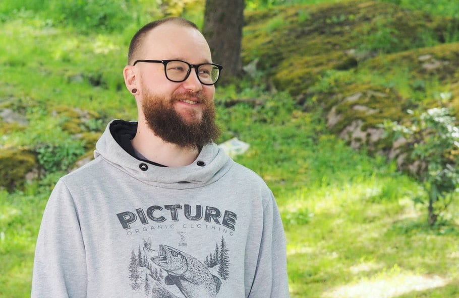Joppe seisoo ulkona ja hymyilee.