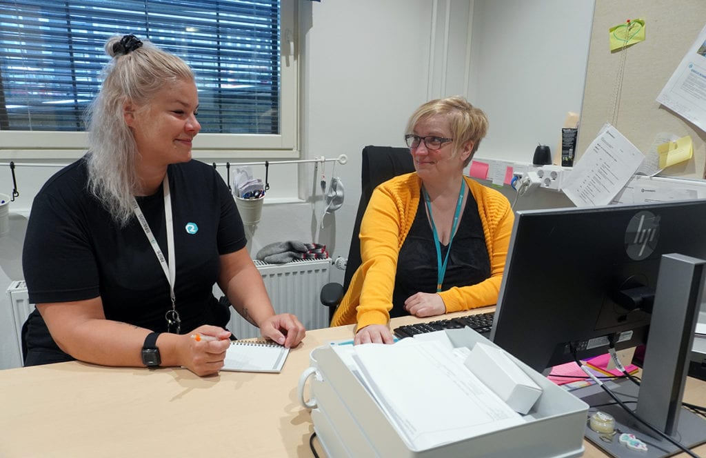 Jeannette Auvinen ja Anne Alhava keskustelevat keskenään tietokoneen äärellä.