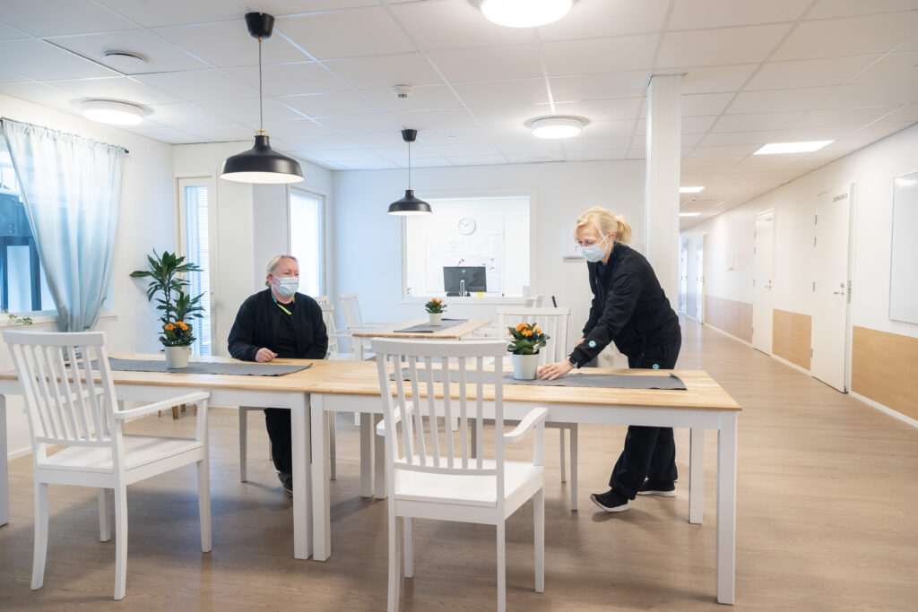 Kaksi naista on valoisassa ruokasalissa.