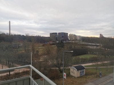 Näkymä parvekkeelta puistoon, joka takana kerrostaloja.